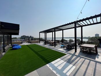 a roof deck with a grassy area and a view of a body of water